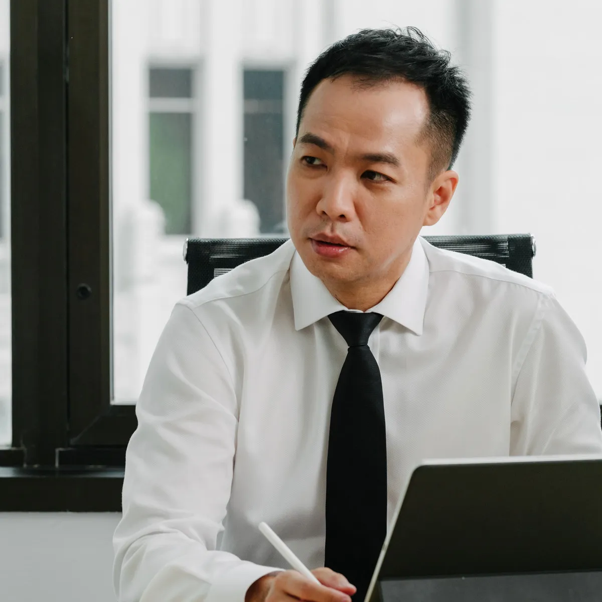 A JCP Law lawyer listening to a client in the firm's meeting room.