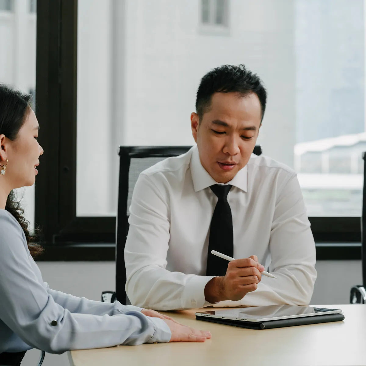 A JCP Law lawyer going through a document with a client at a meeting room table.