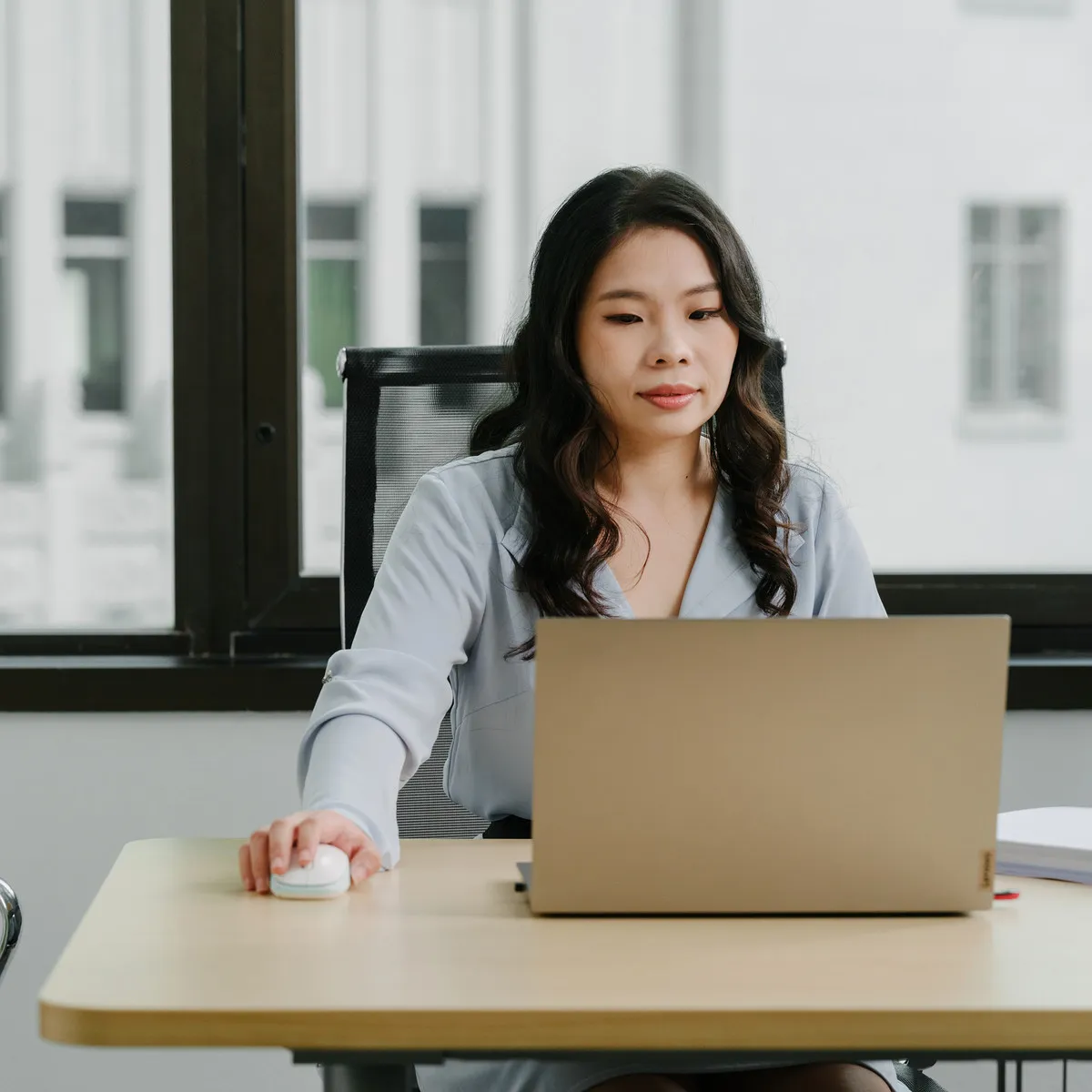 A JCP Law lawyer working at a laptop in the firm's office at Raffles Place.