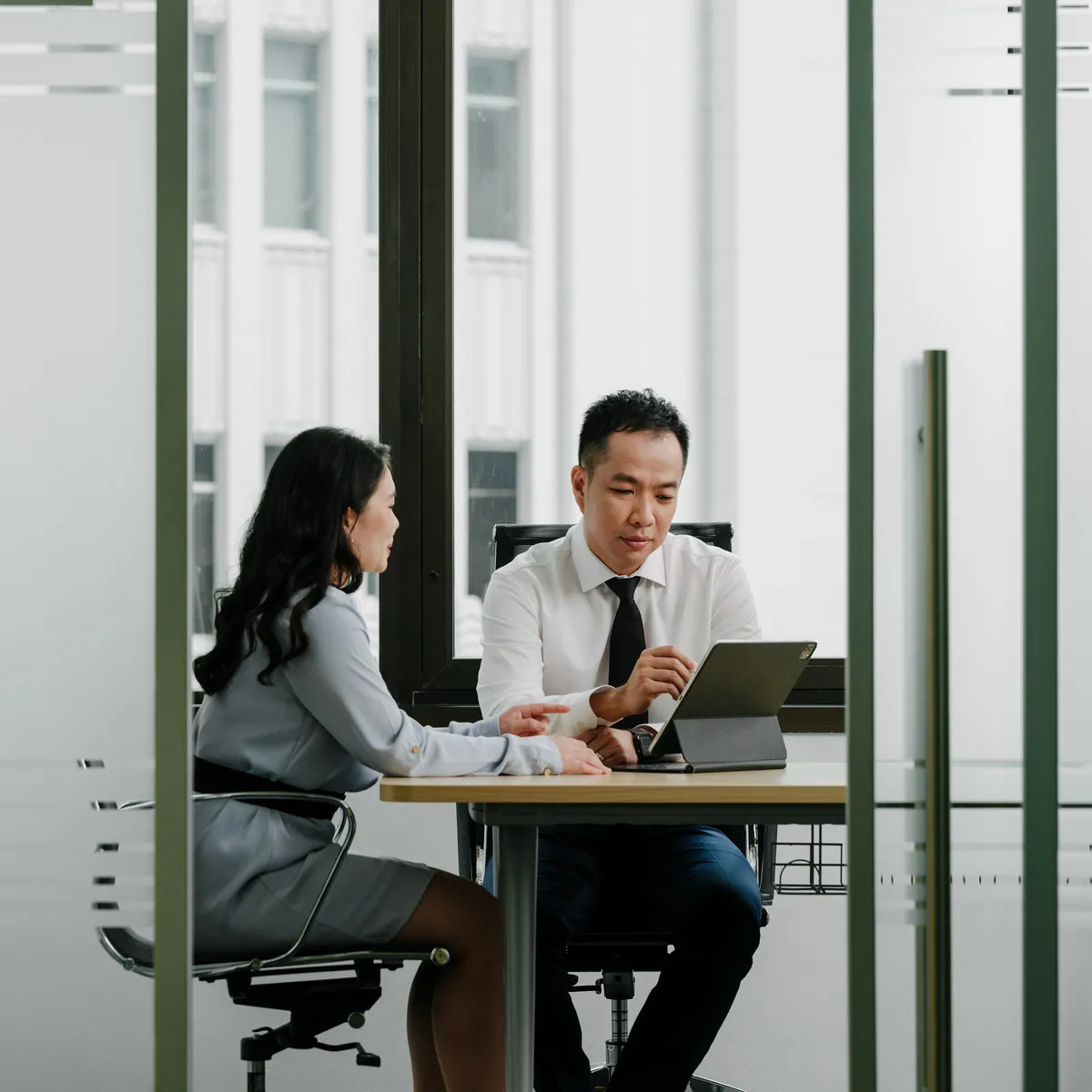 A JCP Law lawyer taking a client through a document in the firm's meeting room.