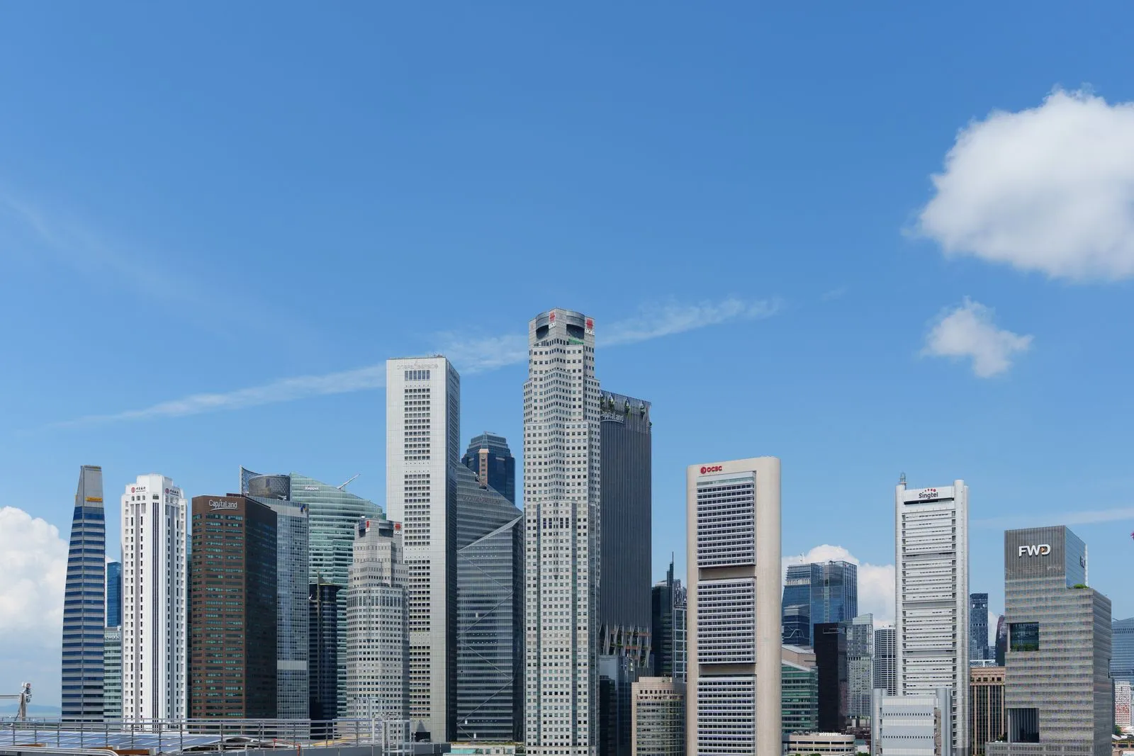 Office towers in Singapore's central business district under a clear sky.